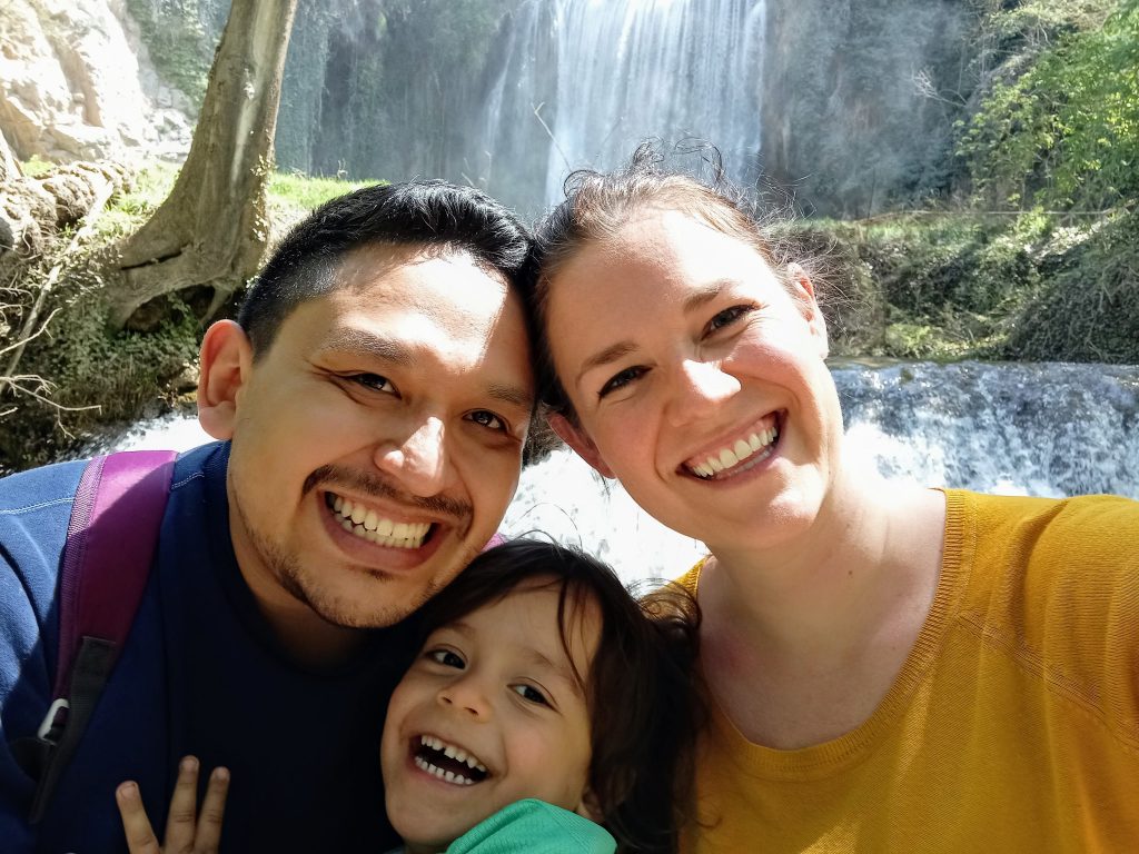 mami, papá, y hijo en frente de una catarata