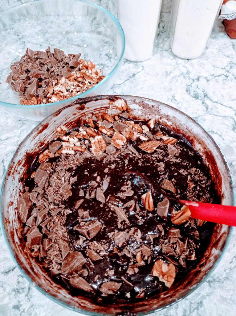 mezclando los trozos de chocolate en la masa de brownies