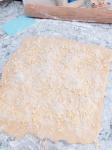 rectángulo de masa cubierto en mantequilla y queso rallado