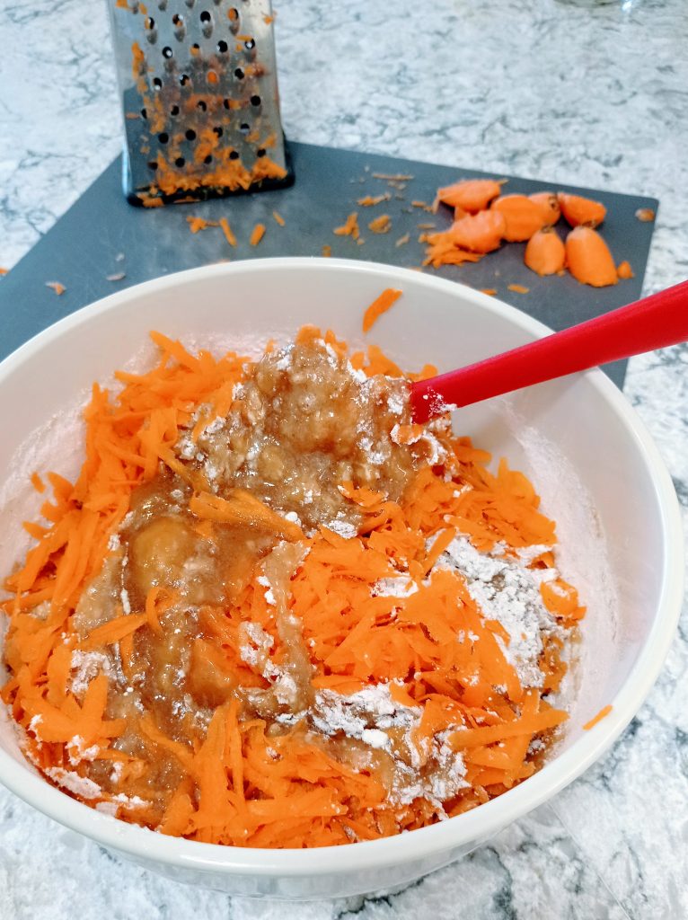 mezclando la zanahoria rallada en la masa de tarta