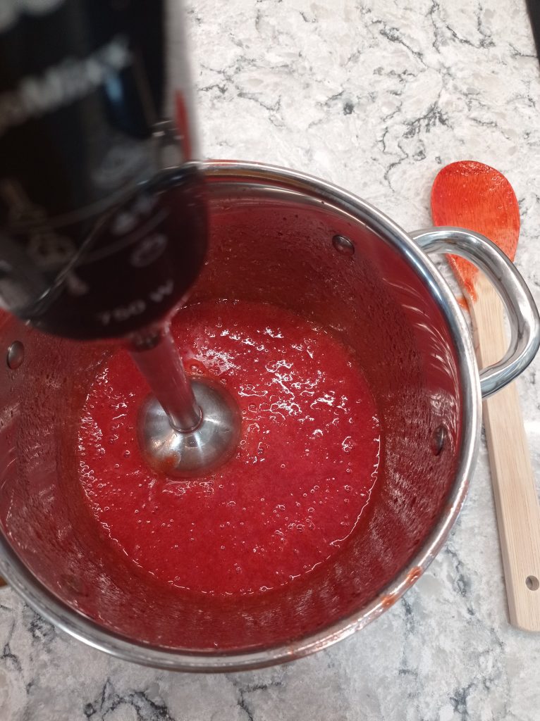 triturando la salsa de fresas con una licuadora