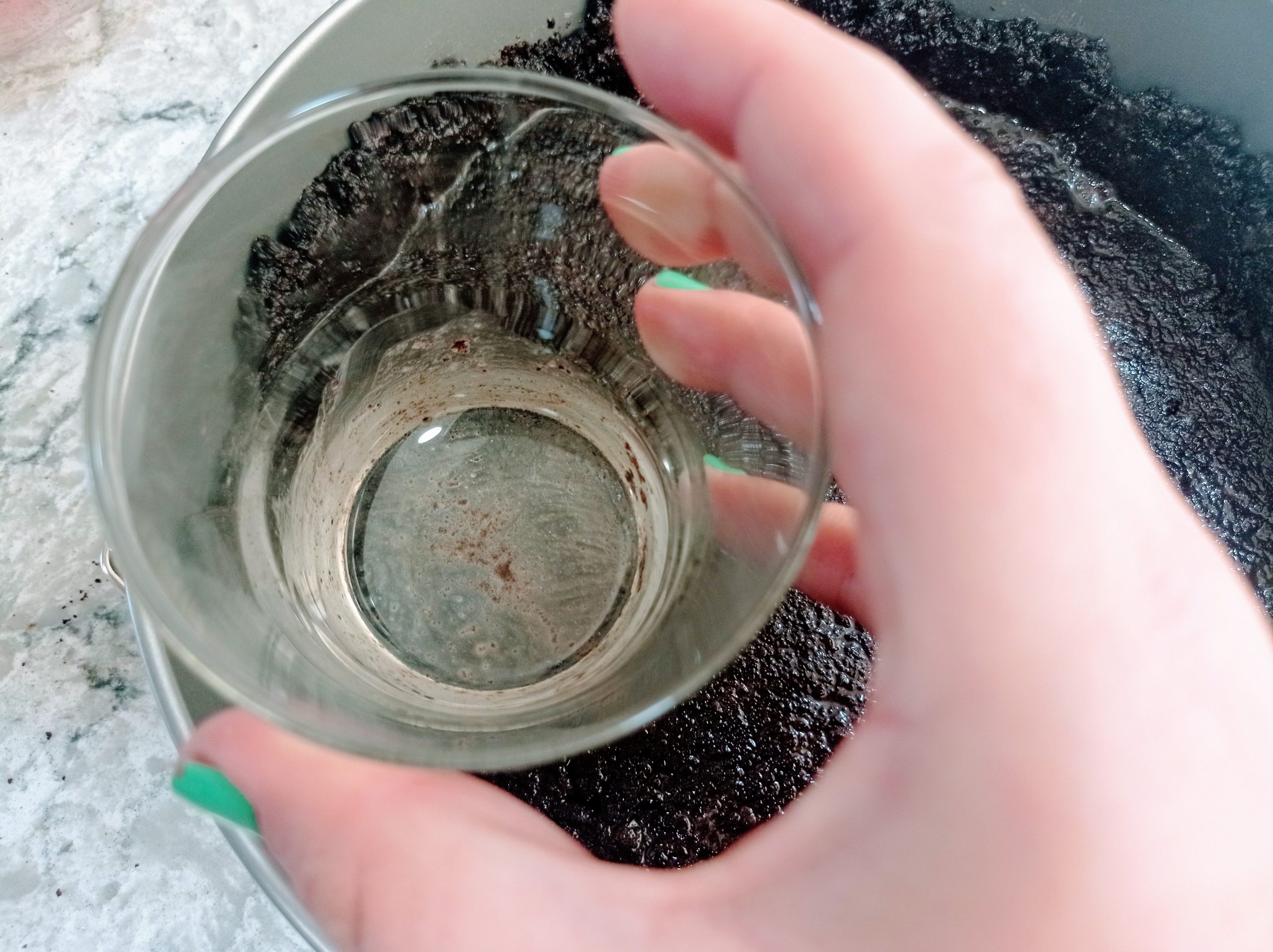 presionando la base de galletas con el fondo de un vaso