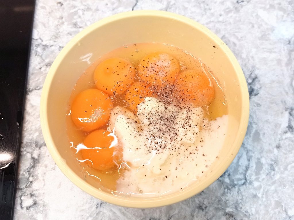 huevos, nata, y especias en un tazón pequeño