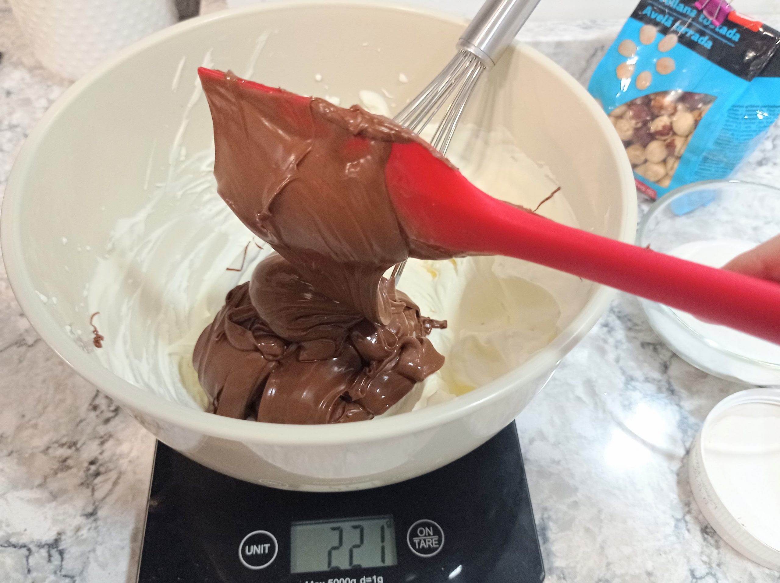 Proporcionando la cantidad de Nutella para mezclar con la nata montada