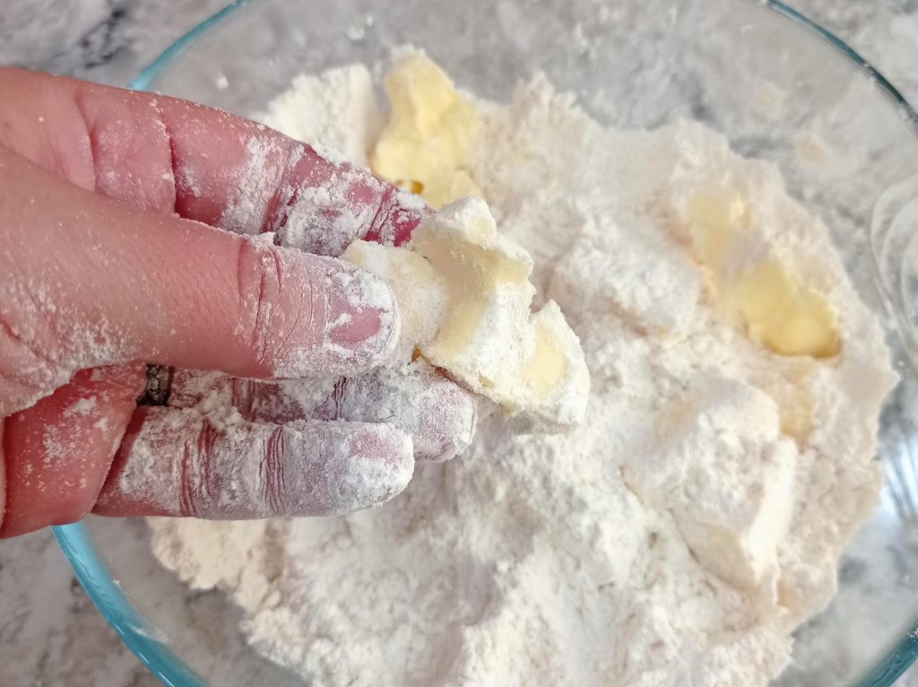 aplastando la mantequilla en los ingredientes secos