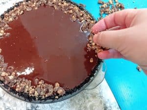 esparciendo trocitos de chocolate encima del cheesecake hecho