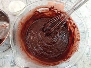 tazón grande con la masa de bizcocho de chocolate con los ingredientes secos y humedos mezclados