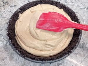aplanando el relleno de mantequilla de maní en la corteza de Oreo