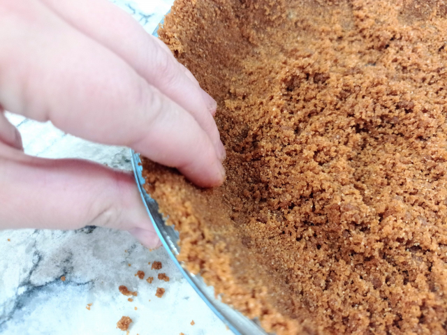 apretando la masa de galletas a los lados del molde