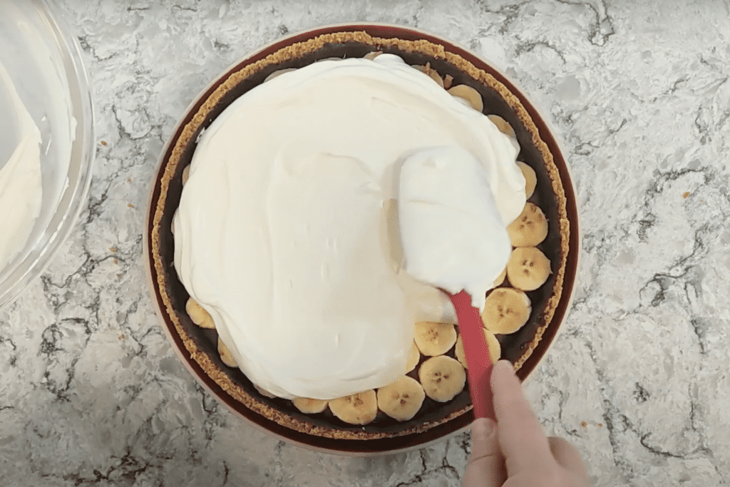 untando la nata montada encima de los plátanos