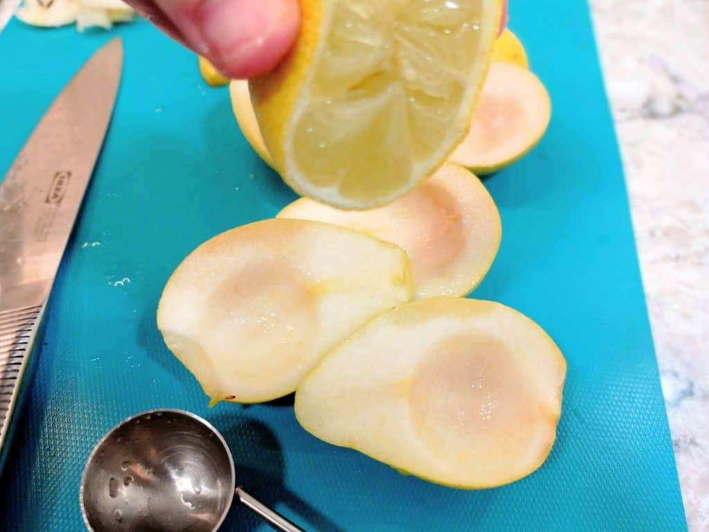 exprimir un limón sobre las peras cortadas