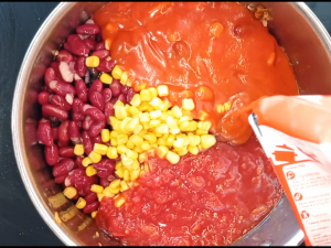 frijoles, maíz, y tomates en la olla