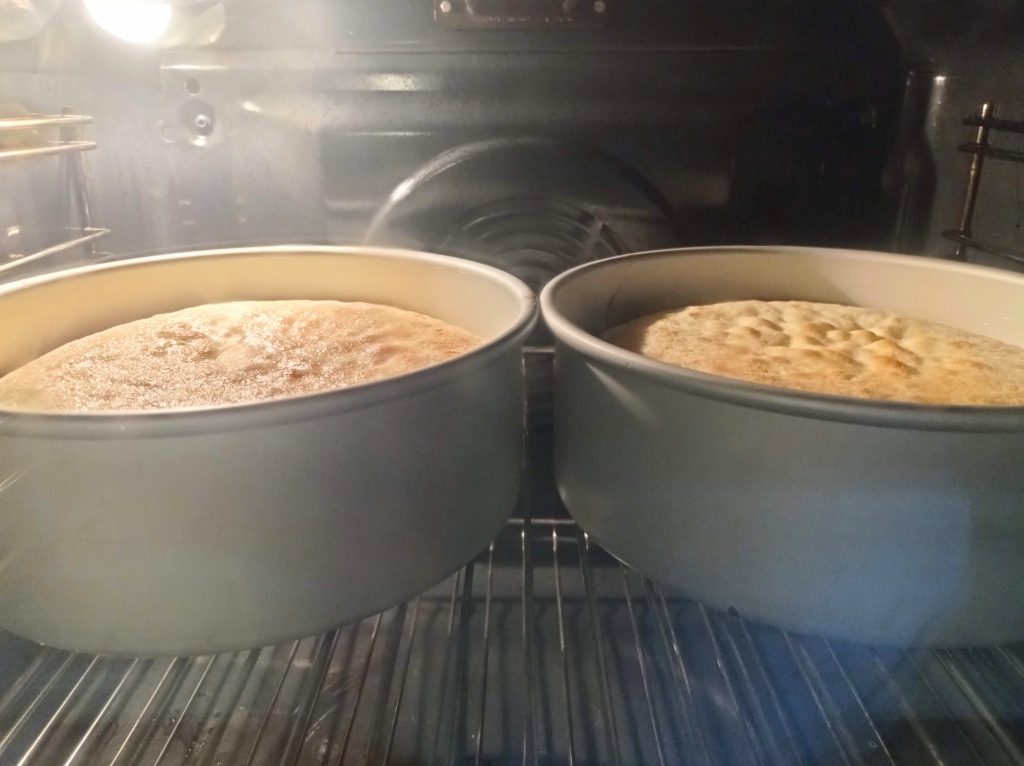 dos moldes redondos con bizcocho en el horno