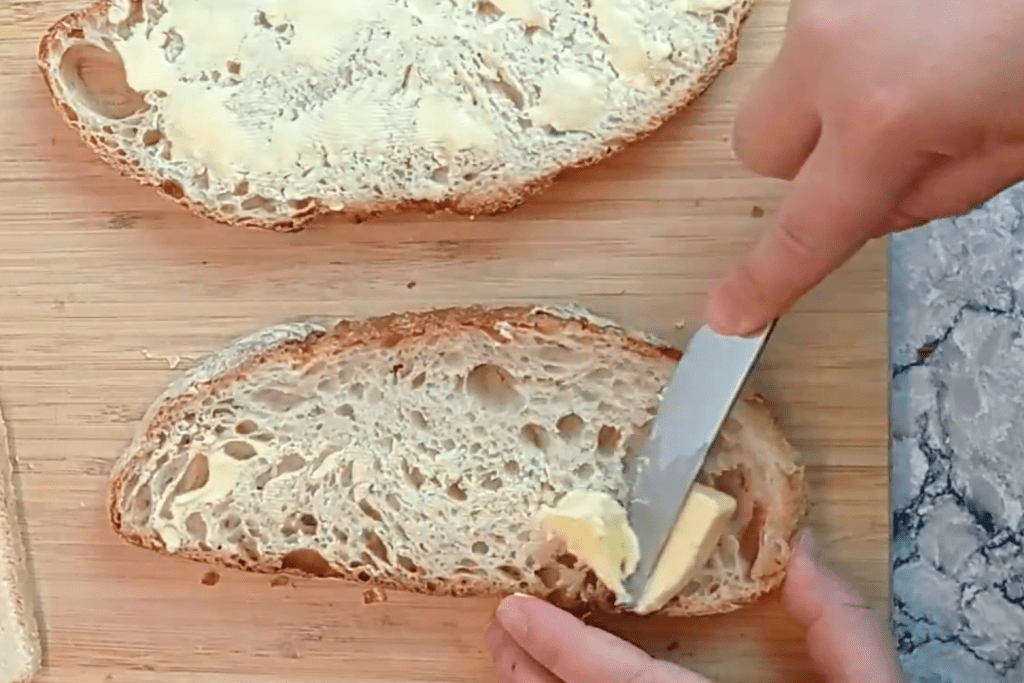 untando mantequilla en los dos panes