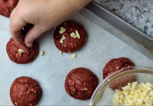 añadir chispas de chocolate encima de las galletas red velvet calientes