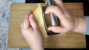 rallar queso para hacer la salsa de queso